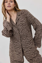 Woman wearing a zebra print outfit against a plain background