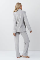 Woman wearing a gray set against a white background