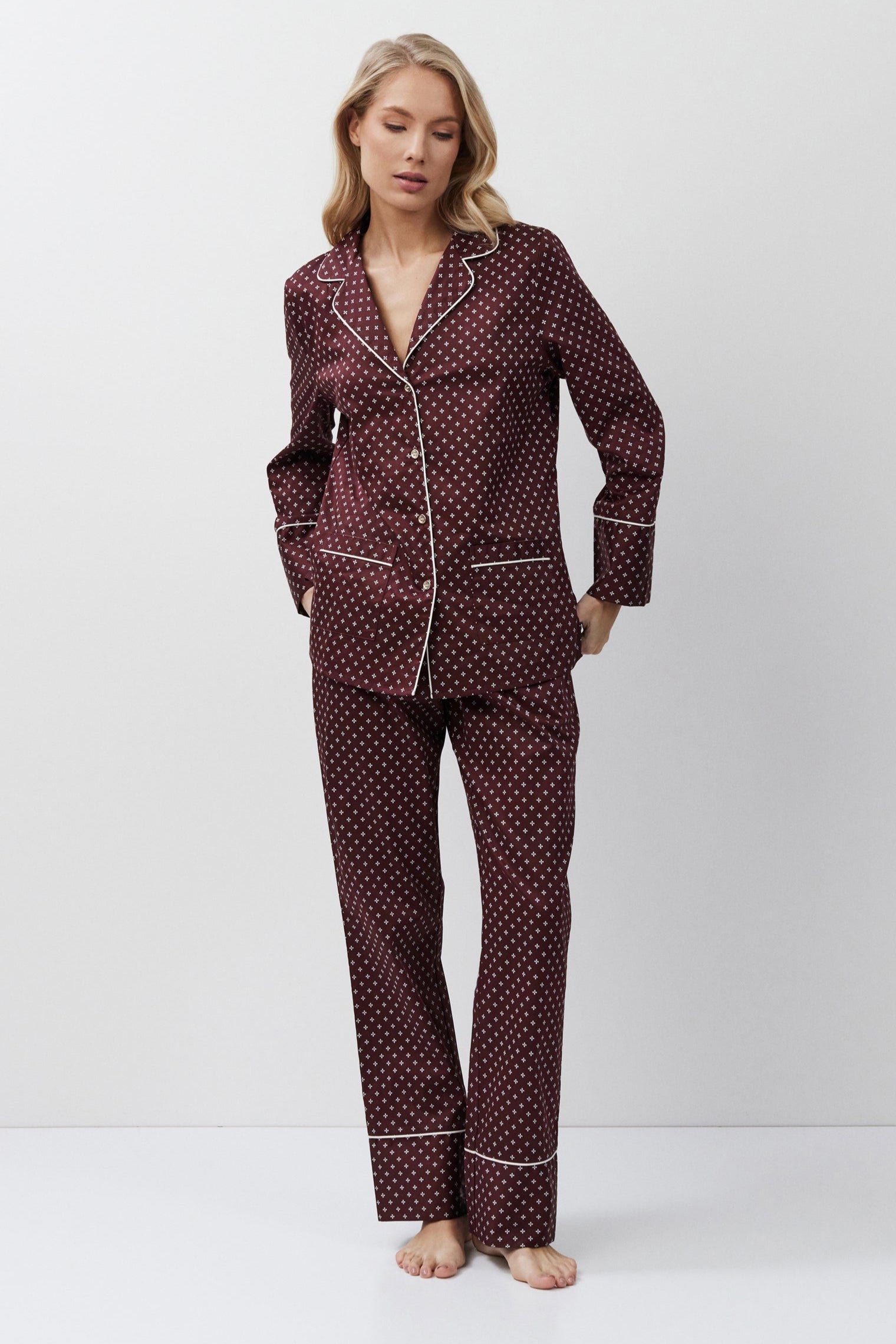 Woman wearing a patterned pajama set against a white background