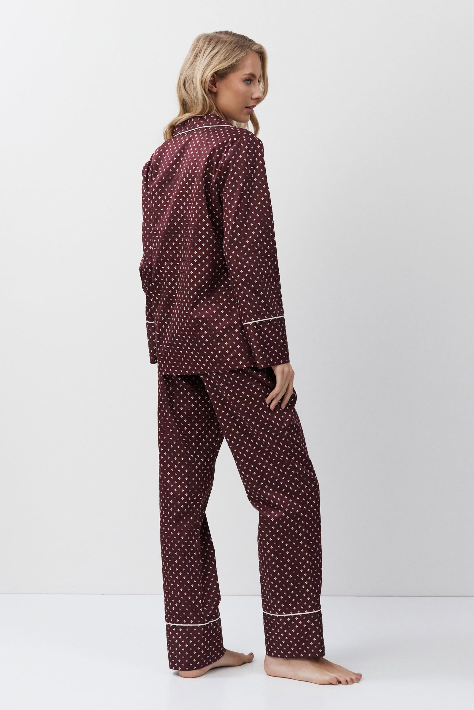Woman wearing a burgundy pajama set on a white background