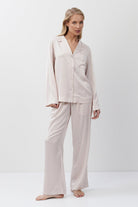 Woman wearing a pink pajama set on a white background