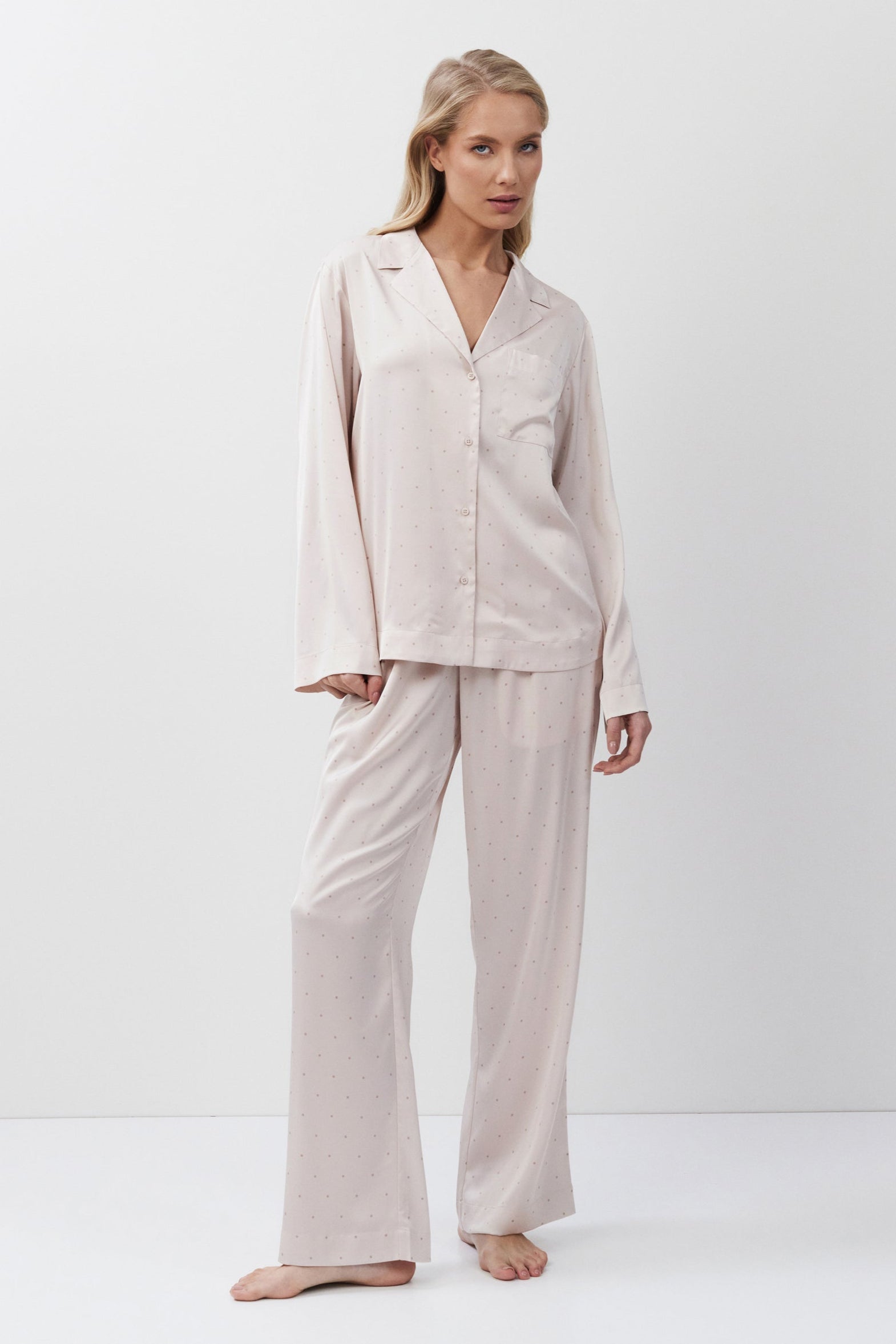Woman wearing a pink pajama set on a white background