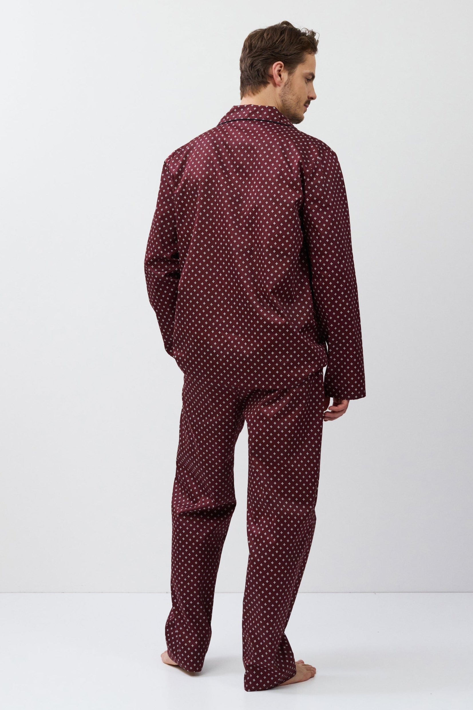 Man wearing a burgundy pajama set on a white background