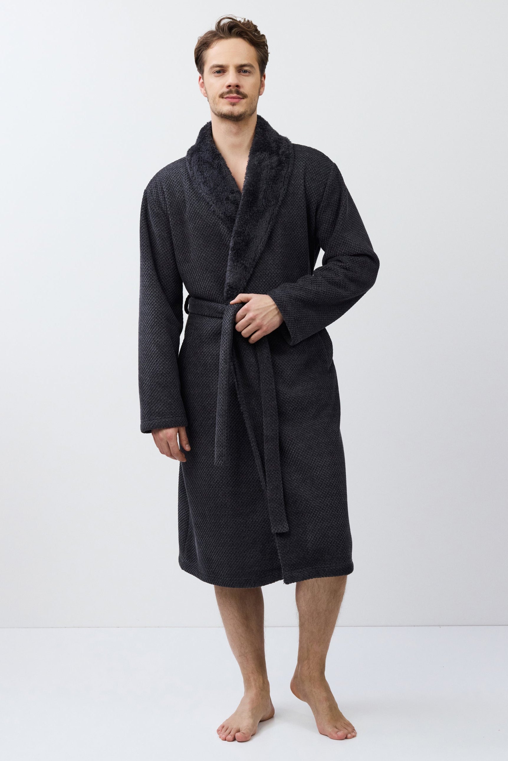 Man wearing a dark gray bathrobe on a white background