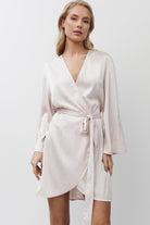Woman wearing a pink gown against a plain background