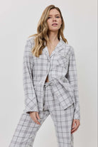 Woman wearing a gray checkered suit against a white background