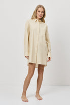 Woman wearing a beige shirt nightdress on a white background
