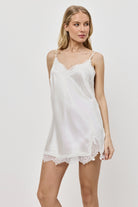 Woman wearing a white nightdress on a plain background