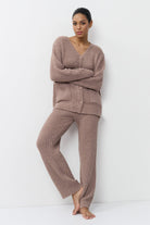 Woman wearing a brown ribbed knit set against a white background