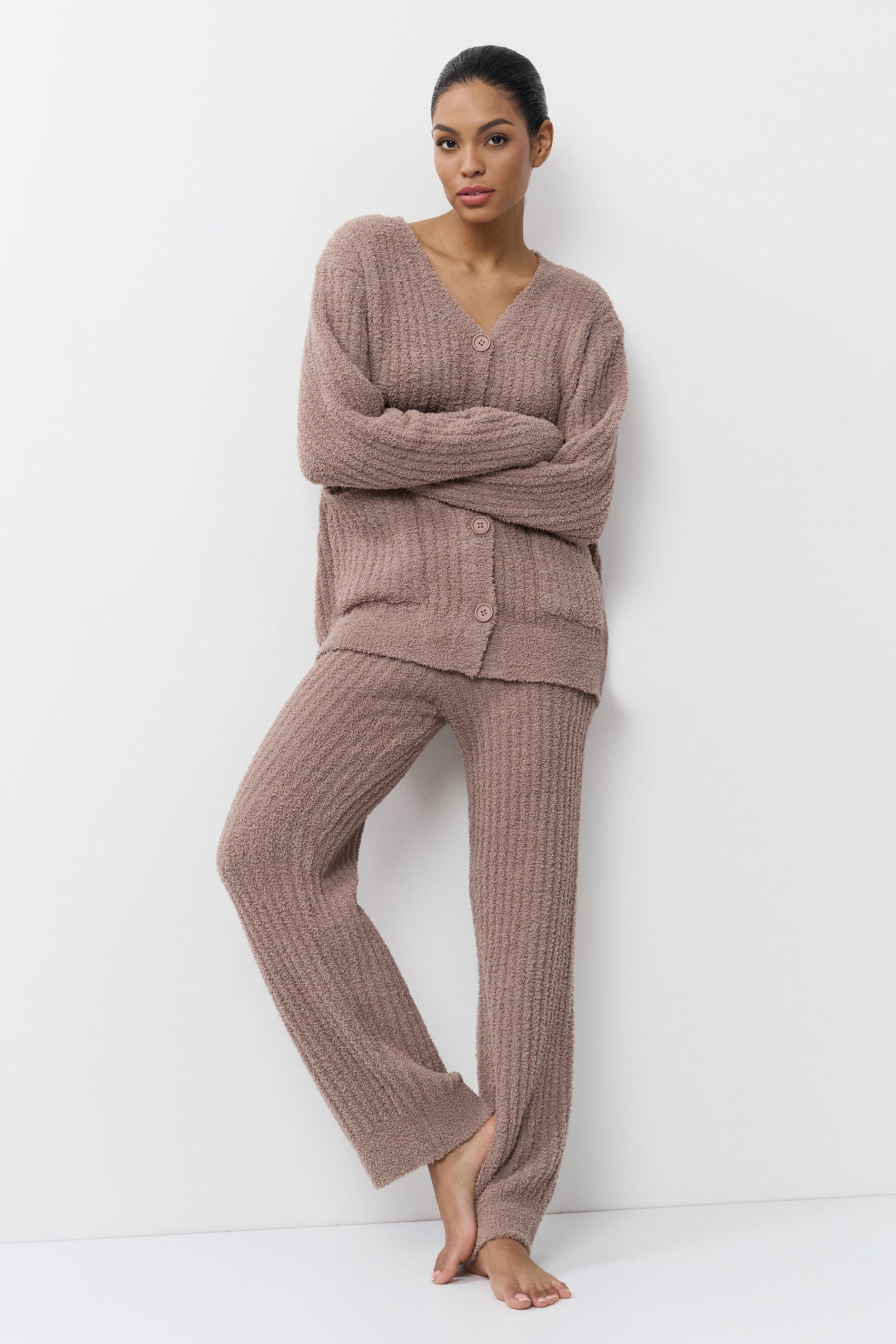 Woman wearing a brown ribbed knit set against a white background