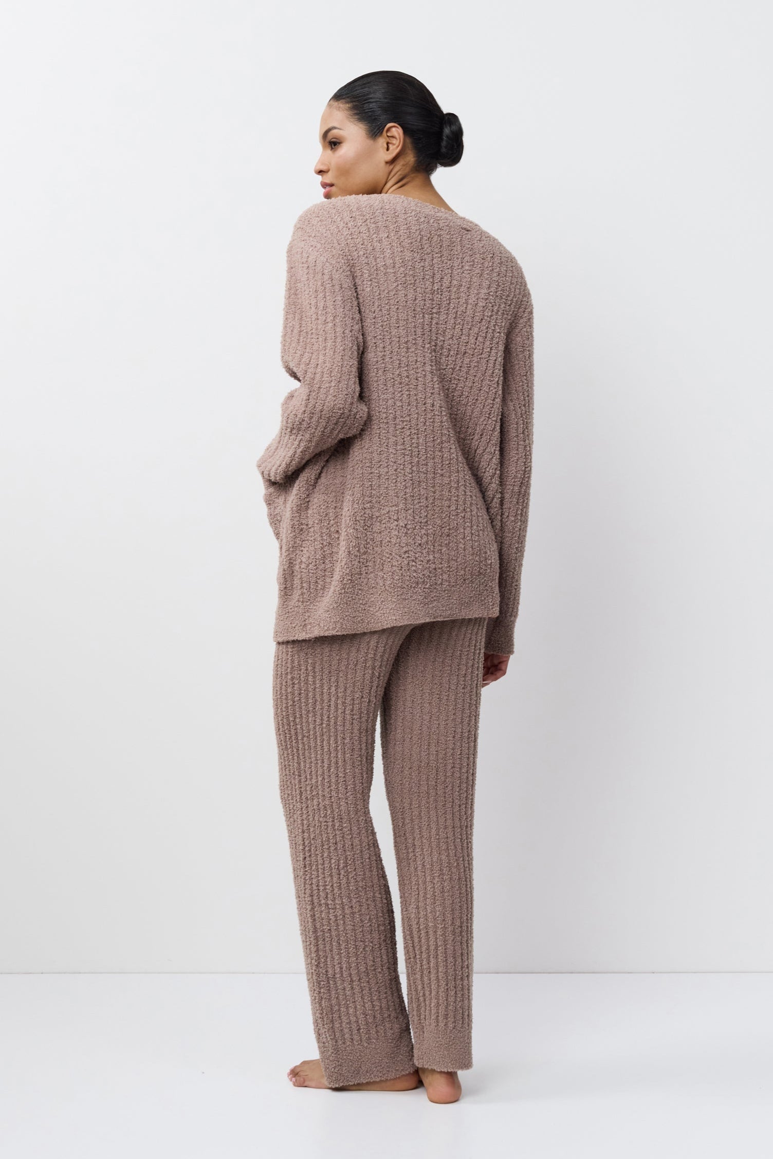 Woman wearing a brown ribbed knit outfit on a white background