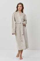 Woman wearing a beige robe on a white background