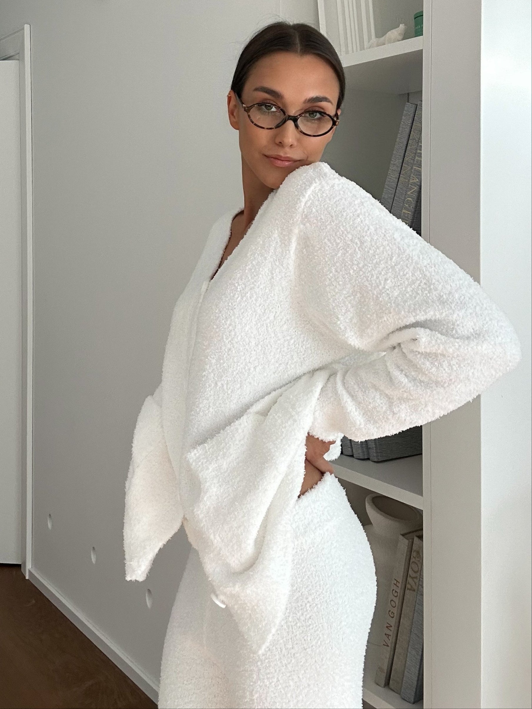 Woman wearing a white textured set in a minimalistic room.