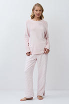 Woman wearing a pink set against a white background