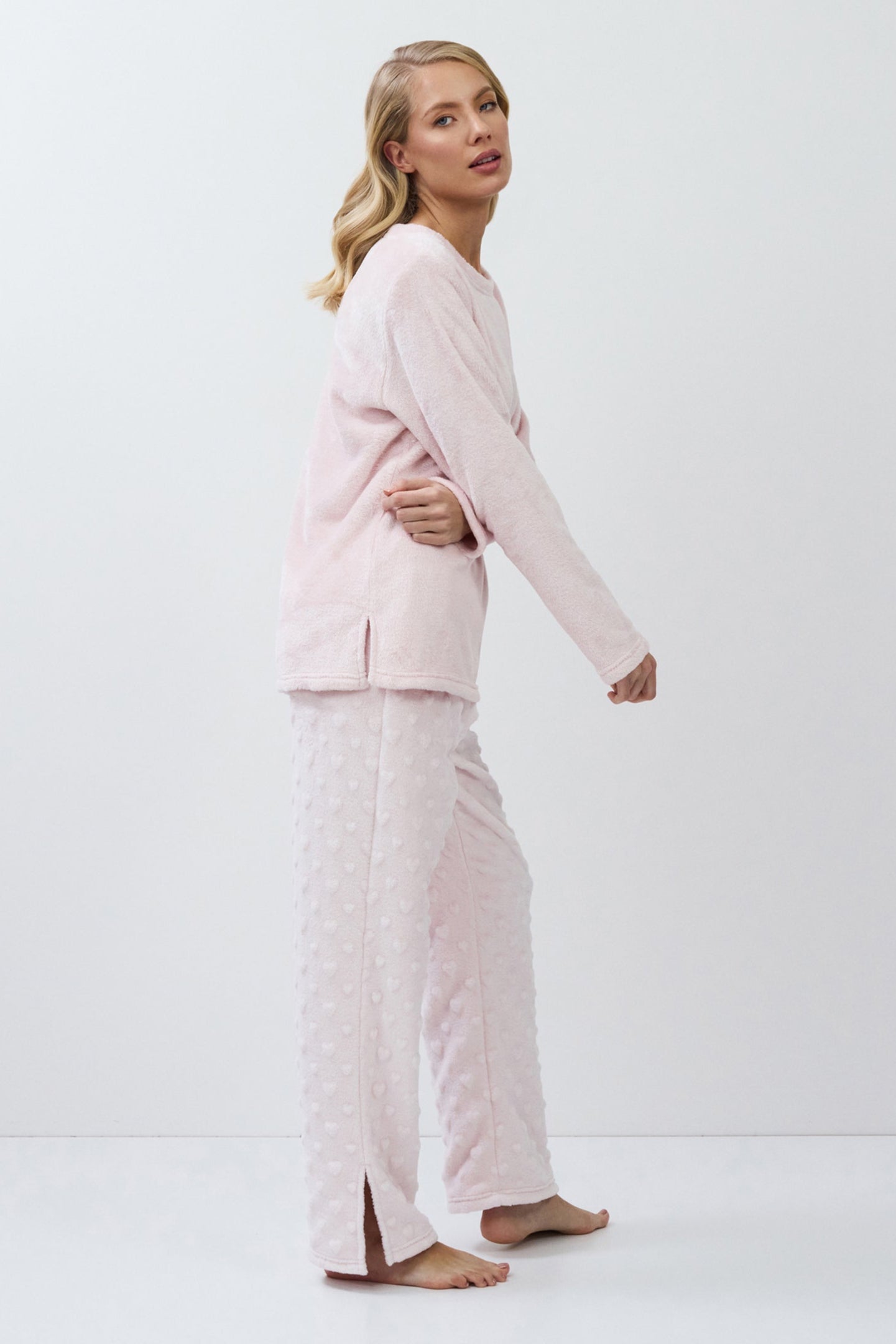 Woman wearing a light pink set on a white background