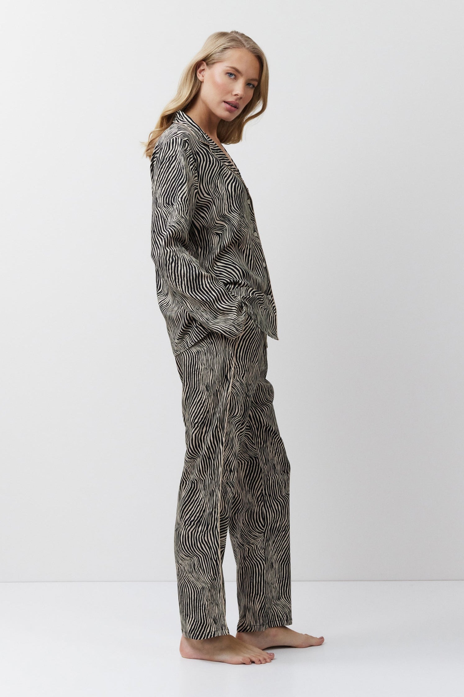 Woman wearing a patterned pajama set on a white background