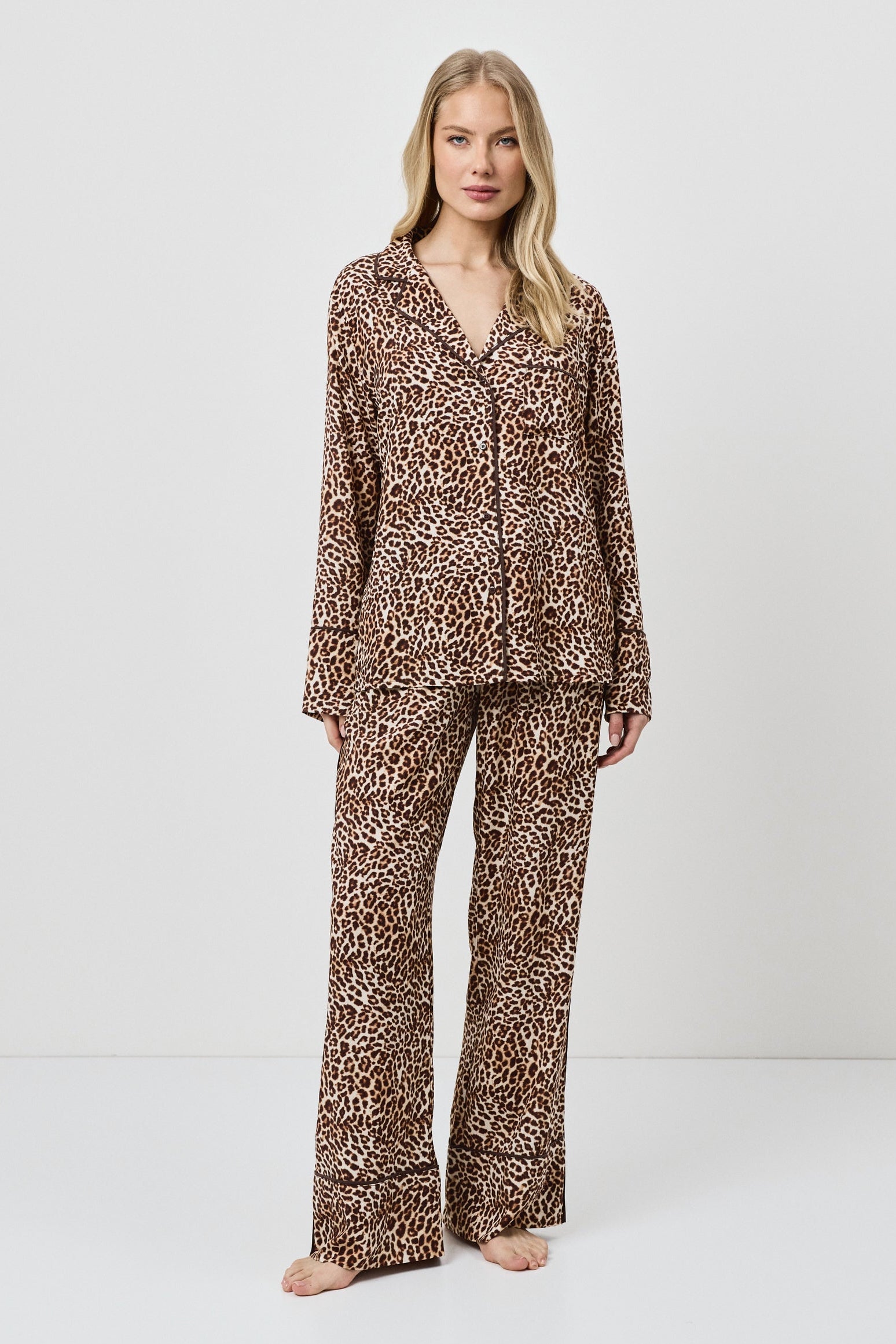 Woman wearing a leopard print pajama set on a white background