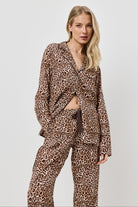 Woman wearing a leopard print pajama set on a white background