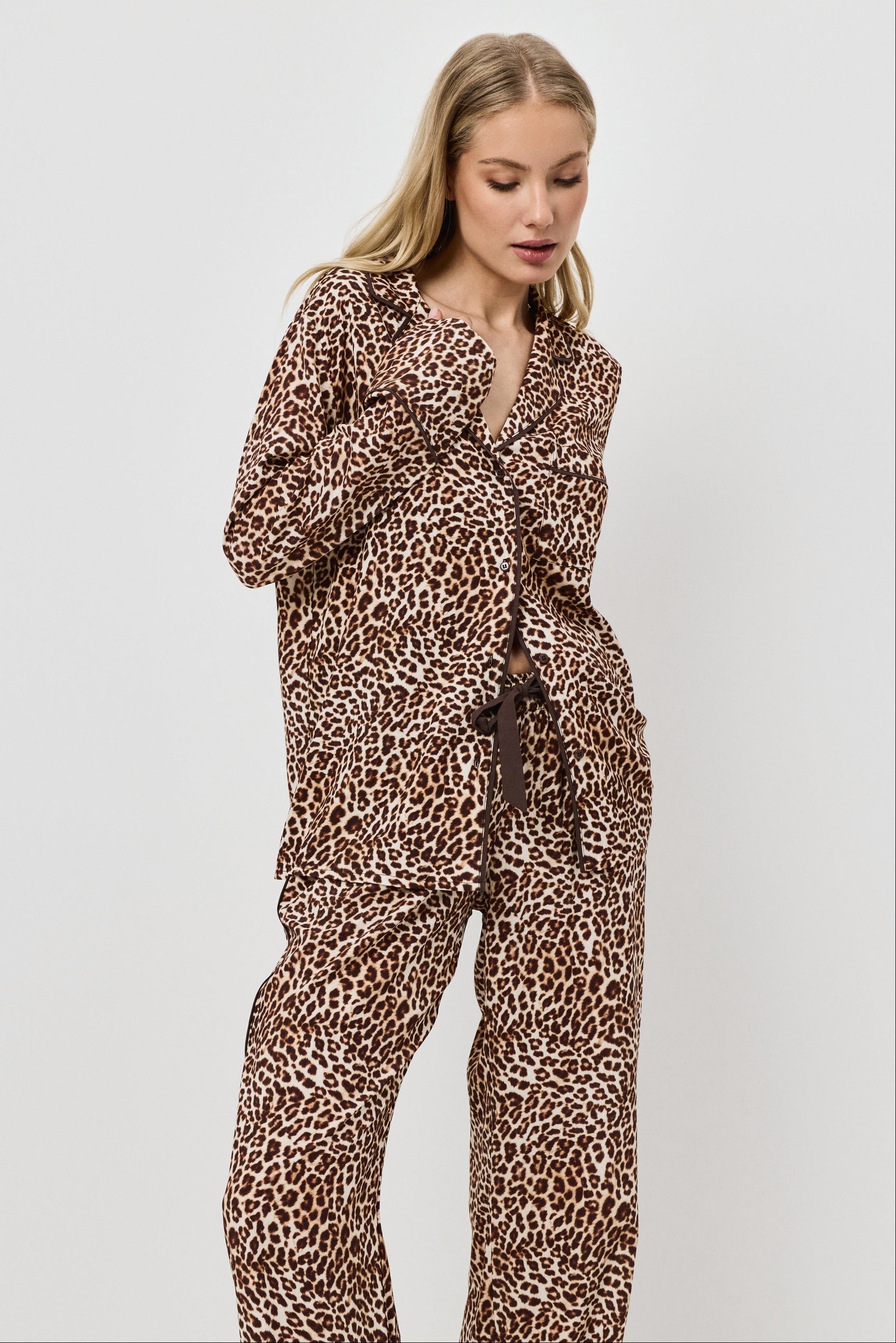 Woman wearing a leopard print pajama set on a white background