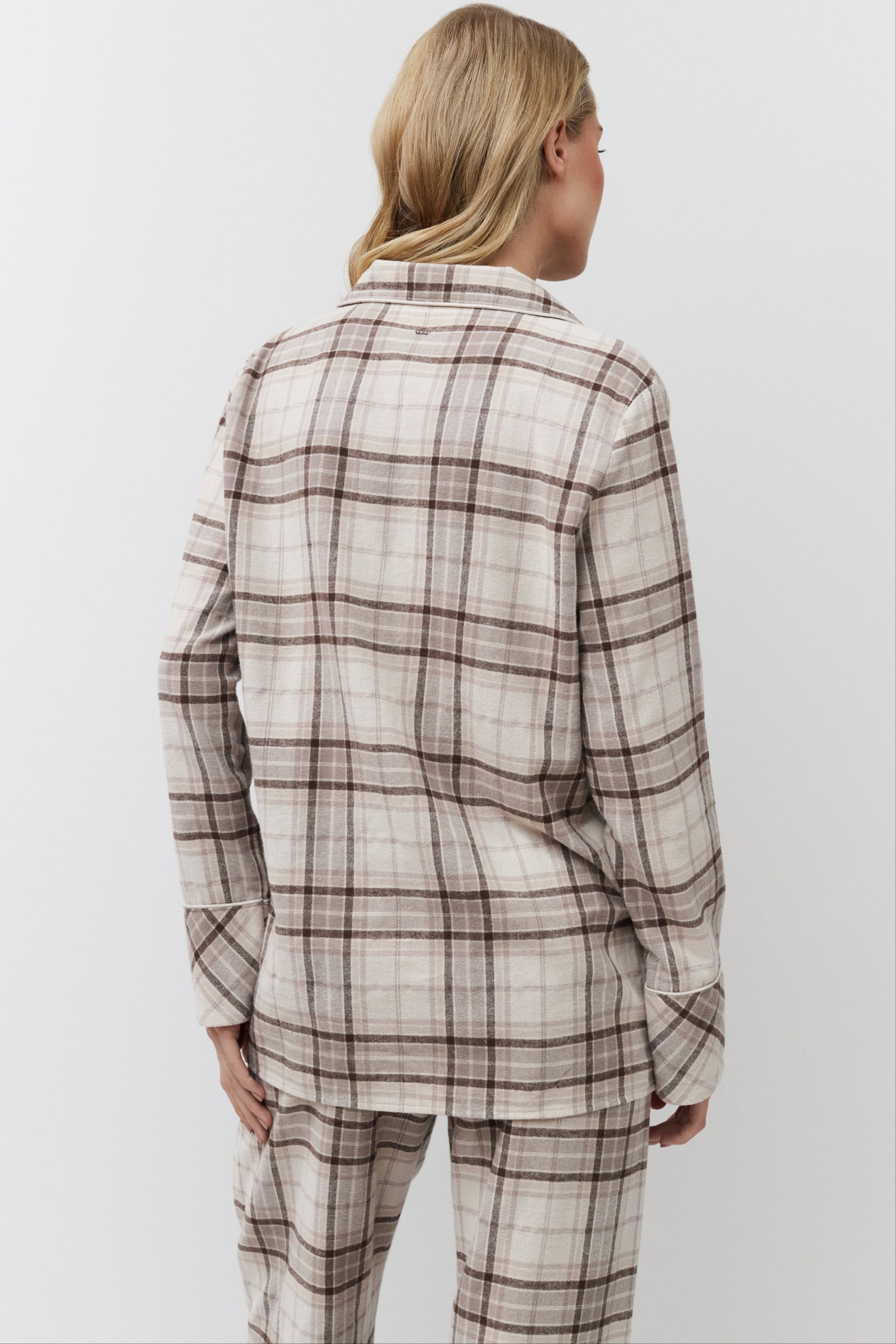 Person wearing a plaid shirt and pants on a white background