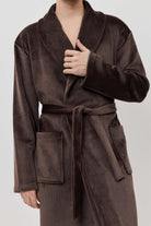 Man wearing a brown robe against a white background