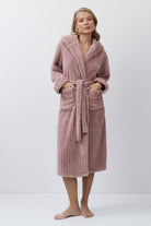 Woman wearing a pink bathrobe against a white background