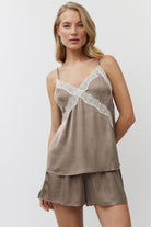 Woman wearing a brown lace-trimmed nightgown with shorts on a white background