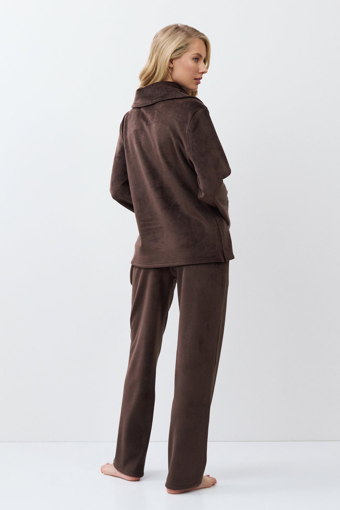Person wearing a brown outfit on a white background