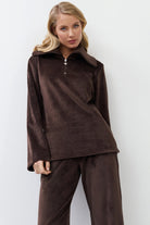 Woman wearing a brown outfit against a white background