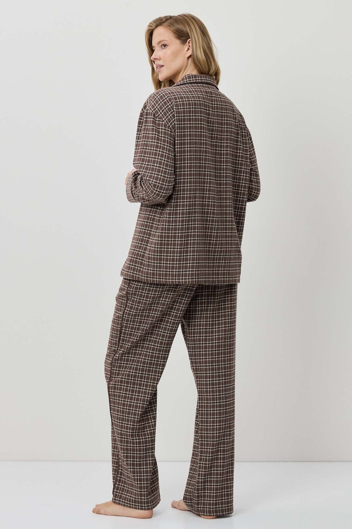 Person wearing a brown plaid suit on a white background