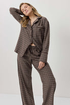Woman wearing a brown plaid suit against a white background