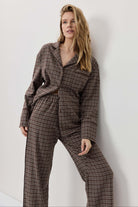 Woman wearing a plaid outfit against a white background