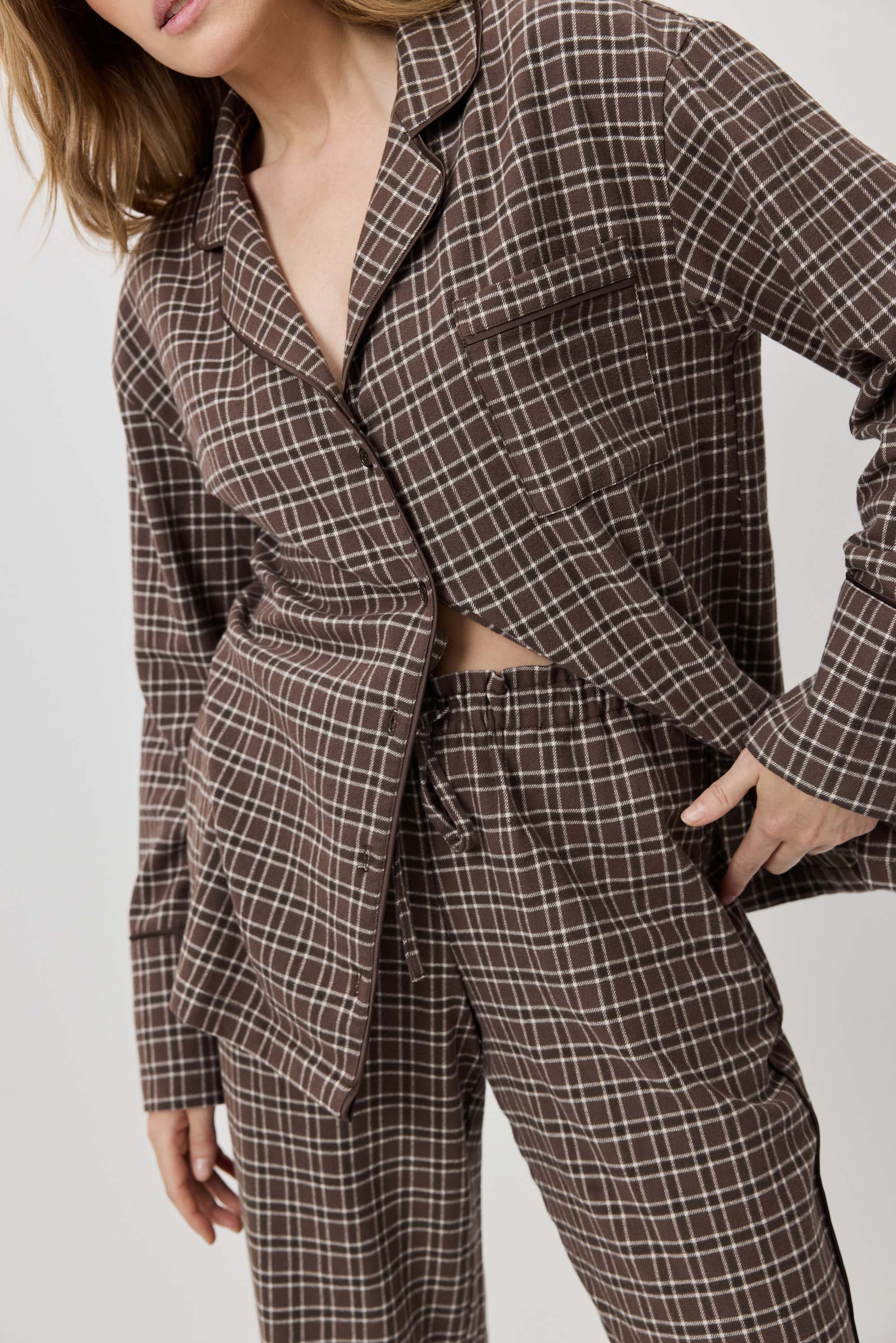 Person wearing a brown plaid suit against a plain background
