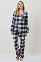 Woman wearing a blue and beige plaid pajama set on a white background