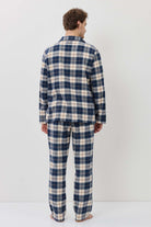 Person wearing a blue and white plaid pajama set against a white background