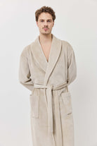 Man wearing a beige robe against a white background