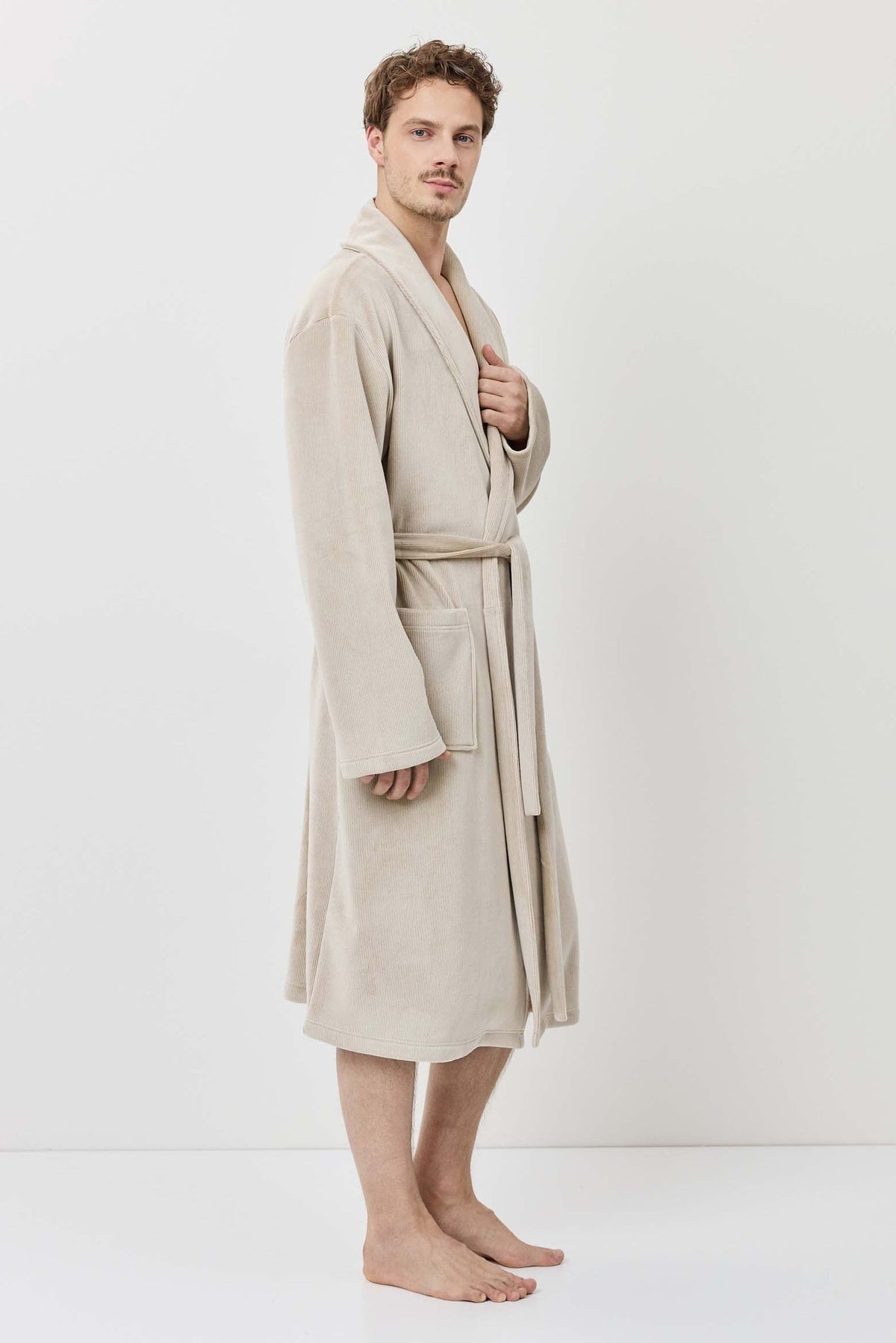 Man wearing a beige robe against a white background