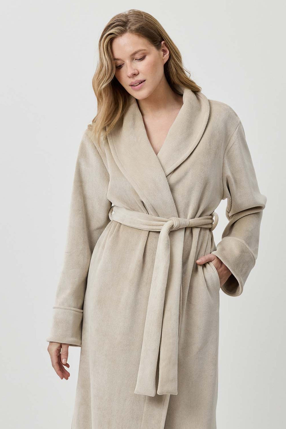 Woman wearing a beige robe against a white background