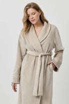 Woman wearing a beige robe against a white background