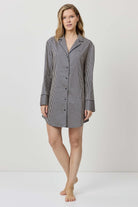 Woman wearing a gray checkered shirt dress on a white background