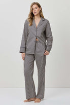 Woman wearing a gray striped pajama set on a white background