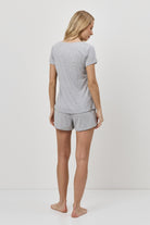 Woman wearing a gray pajama set on a white background