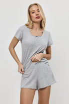 Woman wearing a gray pajama set against a white background