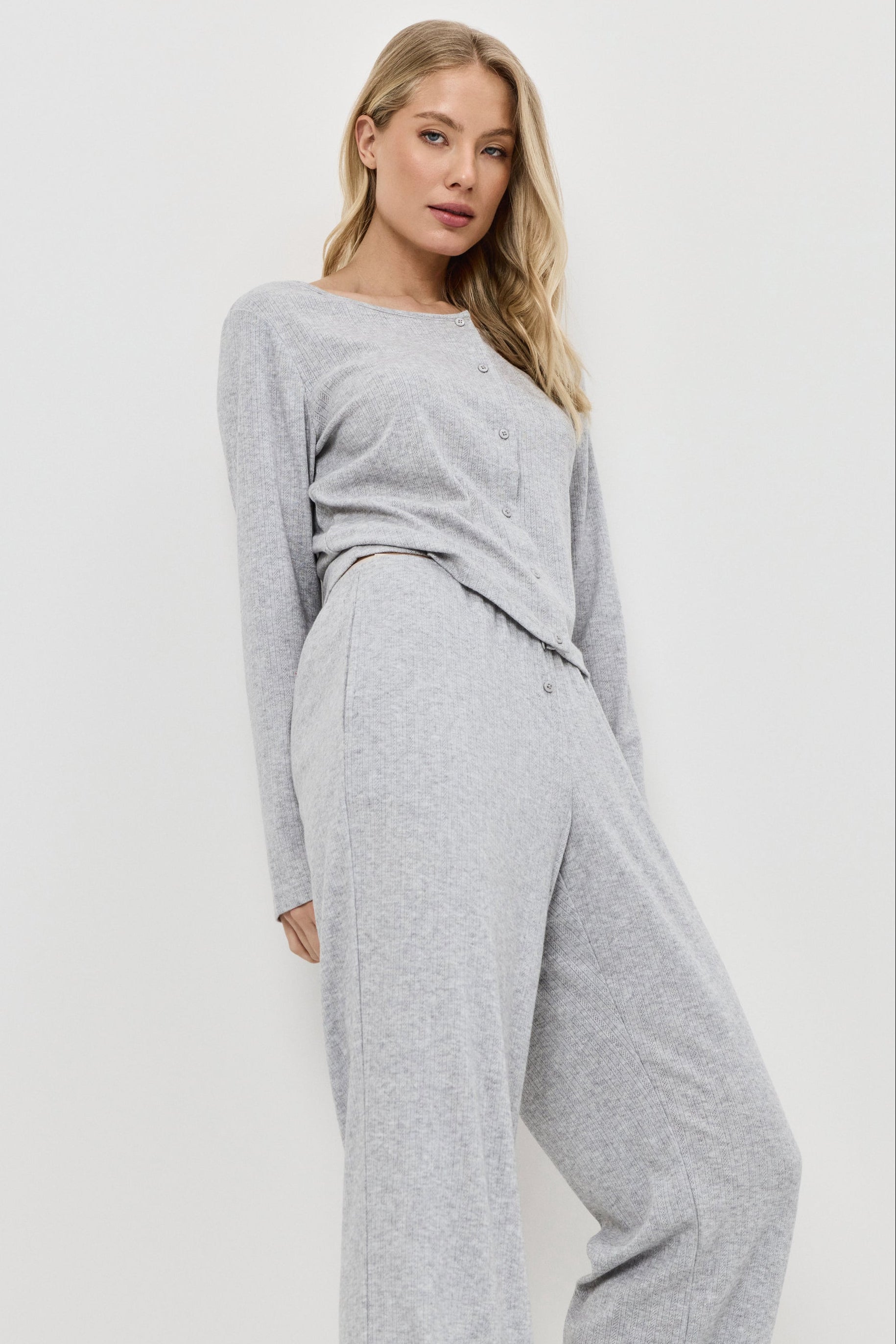 Woman wearing a gray pajama set on a white background