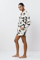 Woman wearing a black and white patterned pajama set on a white background