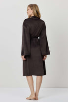 Woman wearing a black robe against a white background