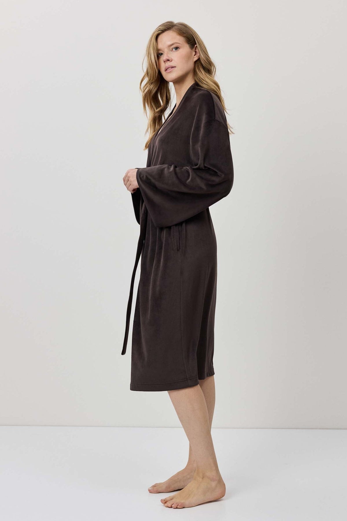 Woman wearing a brown robe against a white background