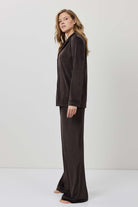 Woman wearing a brown outfit against a white background