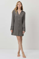 Woman wearing a checkered shirt dress on a white background