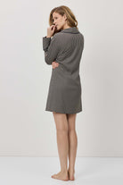 Woman wearing a gray checkered dress against a white background
